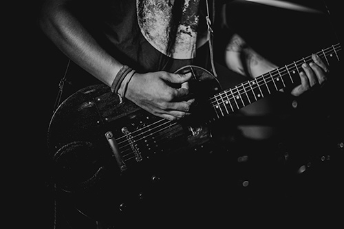 Person strumming a guitar