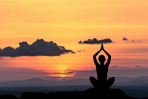 Woman doing yoga pose at sunset