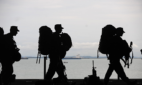 silhouette of soldiers with backpacks