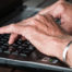 hands typing on laptop