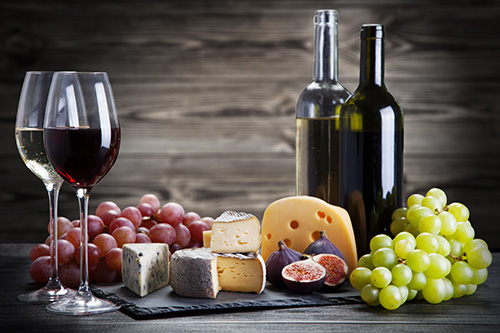 Wine and Cheese Charcuterie board with wine bottles and glasses