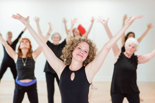 Nia Elaine Wolf and class participants stretching in class