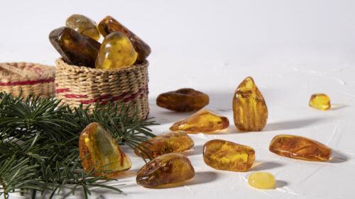 Variety of magical sparkling amber stones on a white plastered surface. Material for jewelers, stone healing, strong talisman.