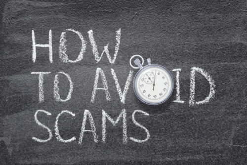 how to avoid scams phrase written on chalkboard with vintage stopwatch used instead of O