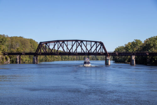 Boat passing under a rusted metal bridge on the Erie Canal Boats passing under a rusted metal bridge on the Erie Canal