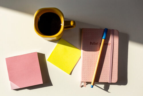 Ready for bullet planning of the week at home office Bullet journal, pen, post it notes and a coffee cup