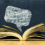 Chat symbol above vintage old book on blackboard background