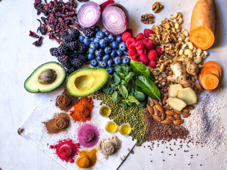 Multi colored vegetables, fruits, legumes, nuts and spices on wooden table Anti-inflammatory vegetables, fruits, legumes, nuts and spice for health