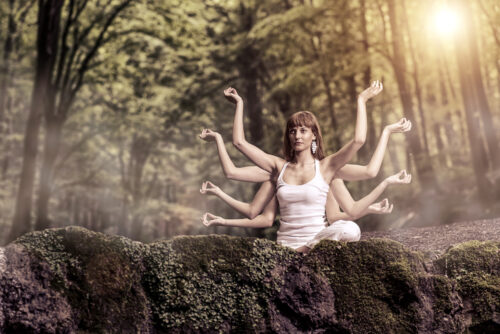 Eight arm woman sitting on a forest and pray