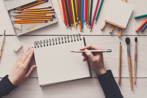 Workplace of artist, flat lay, top view, desktop Draw in sketchbook. Creative artist workspace top view. Background of painting, art stationery