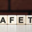 SAFETY - business financial concept on on a dark brick background. Wooden cubes with text