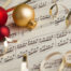 A classical music score with baubles and ribbons.