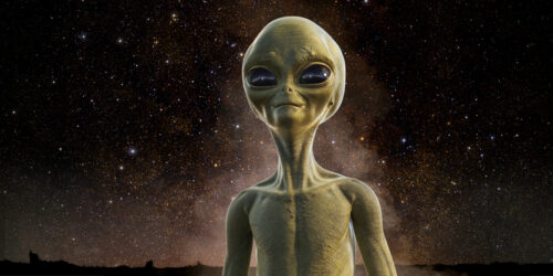 Portrait Of Alien Being Under Night Sky A portrait of the head and upper torso of a yellow-green extra terrestrial being standing under a clear starry sky with some background haze.